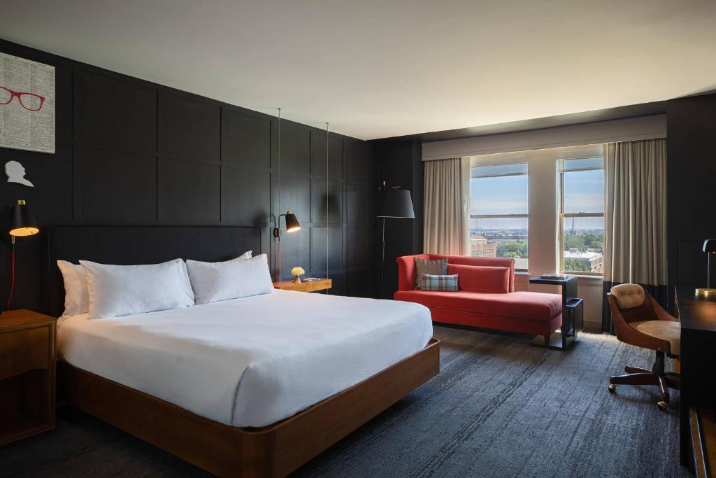 a hotel room with a bed and a red chair at Renaissance Philadelphia Downtown Hotel in Philadelphia