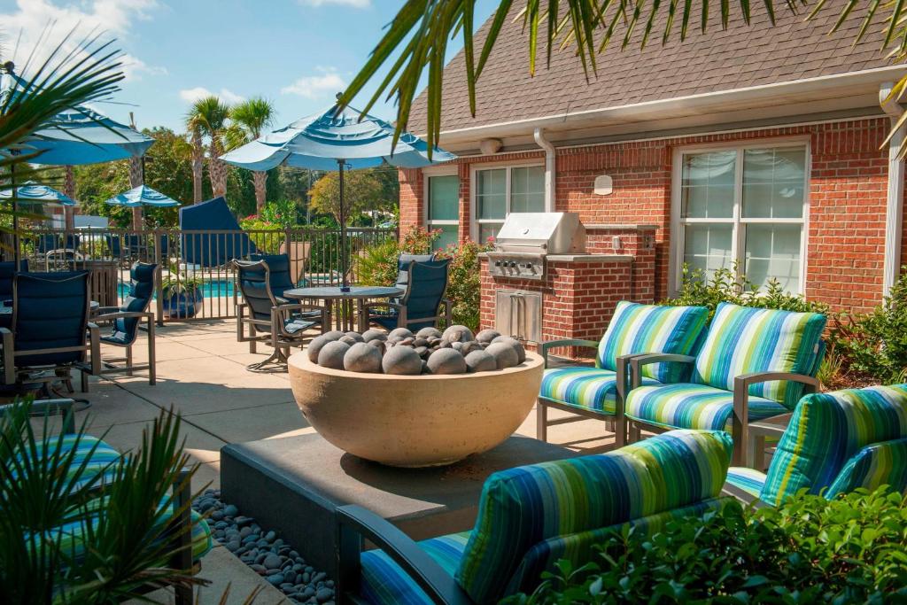 een patio met stoelen en een kom ballen bij Residence Inn by Marriott Pensacola Downtown in Pensacola