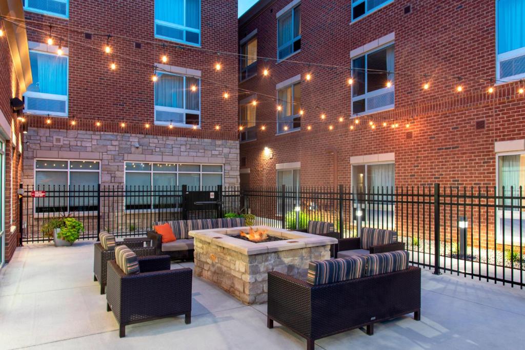 a patio with a fire pit in front of a building at TownePlace Suites by Marriott Louisville North in Jeffersonville