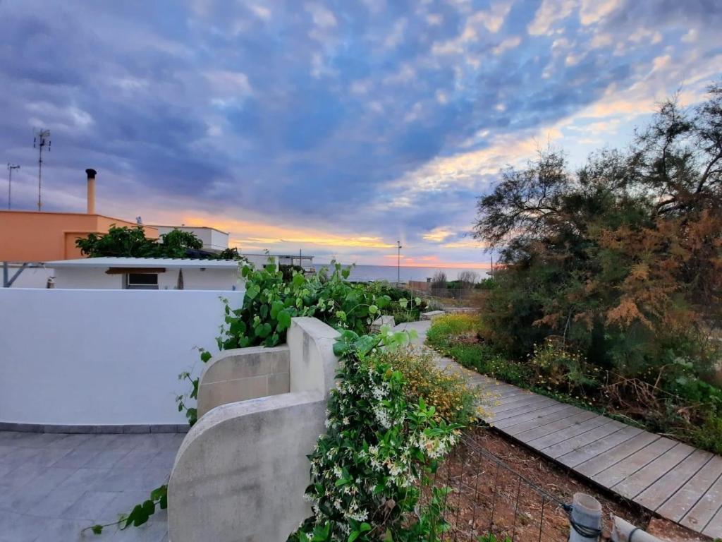 einen Garten mit einem weißen Zaun und einem Ziegelweg in der Unterkunft MONOLOCALE LA GROTTA in Capilungo