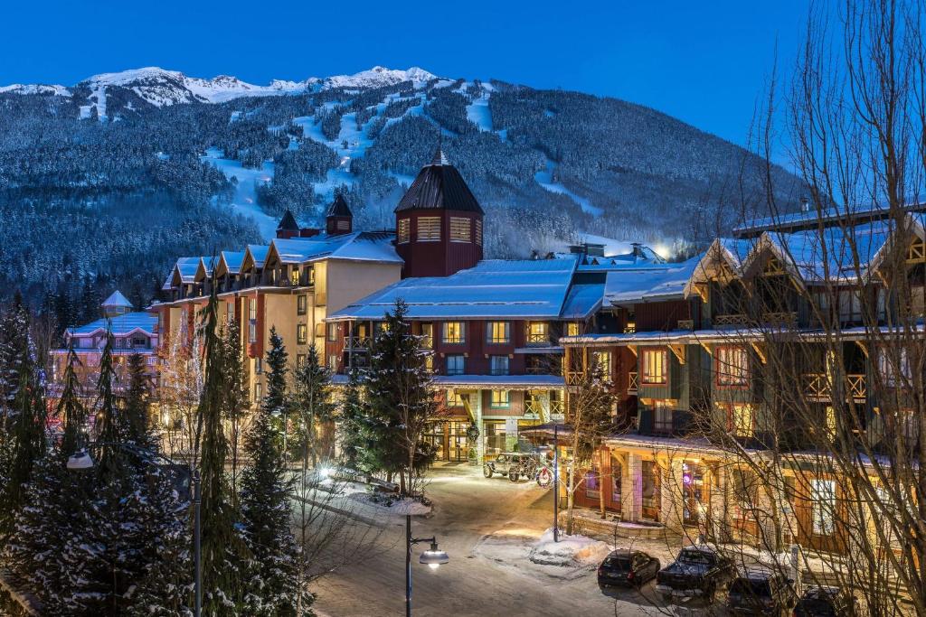 a hotel in the mountains with snow on the ground at Delta Hotels by Marriott Whistler Village Suites in Whistler