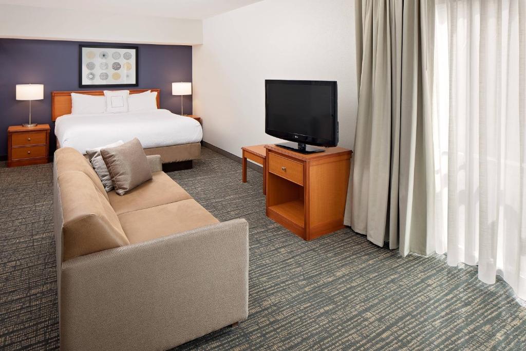 une chambre d'hôtel avec un lit, un canapé et une télévision dans l'établissement Residence Inn Lexington North, à Lexington
