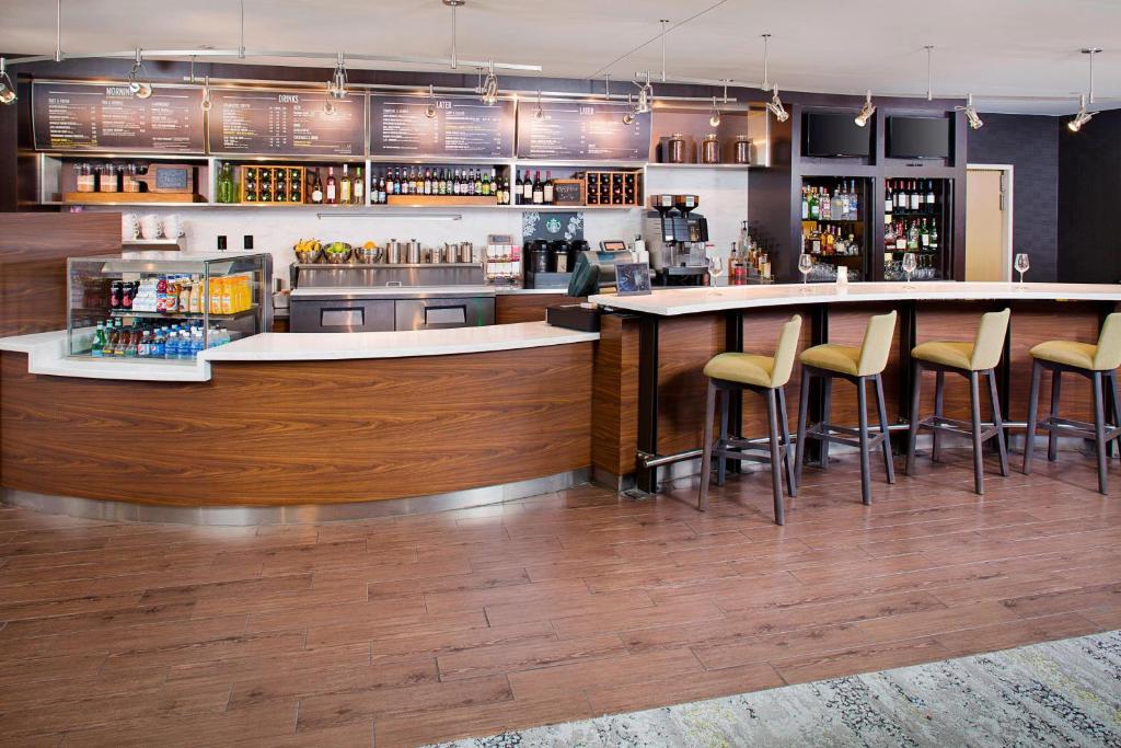 a kitchen with a bar with stools in a restaurant at Courtyard by Marriott Roanoke Airport in Roanoke