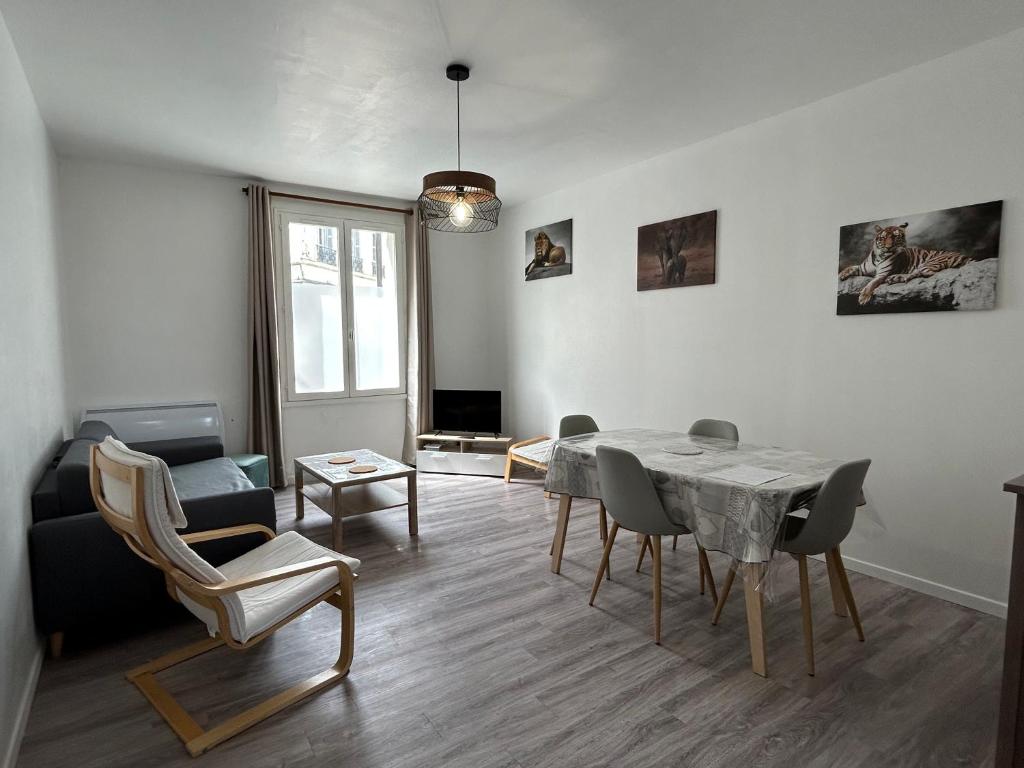 een woonkamer met een eettafel en stoelen bij Le Parmentier - 1 place de parking privative in Saint-Aignan