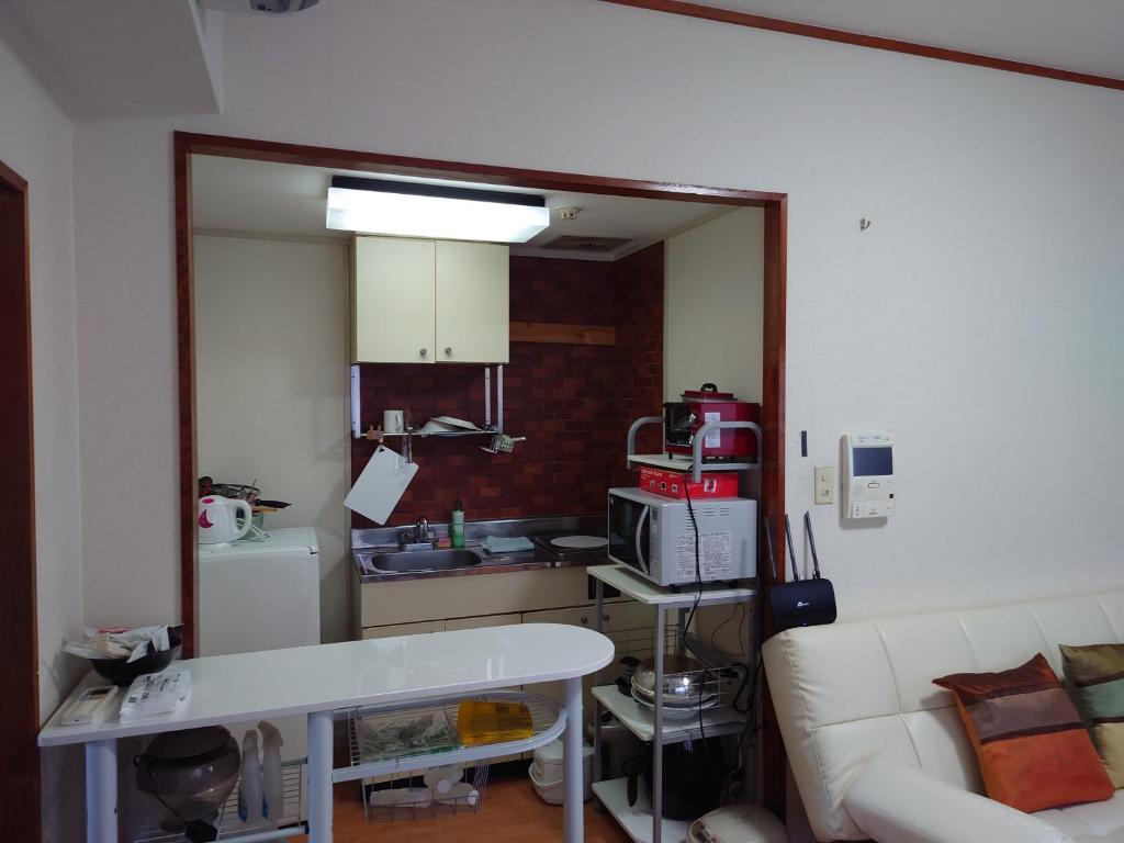 a living room with a white couch and a kitchen at 39.51LDK京都市内中心部四条烏丸.5 in Kyoto