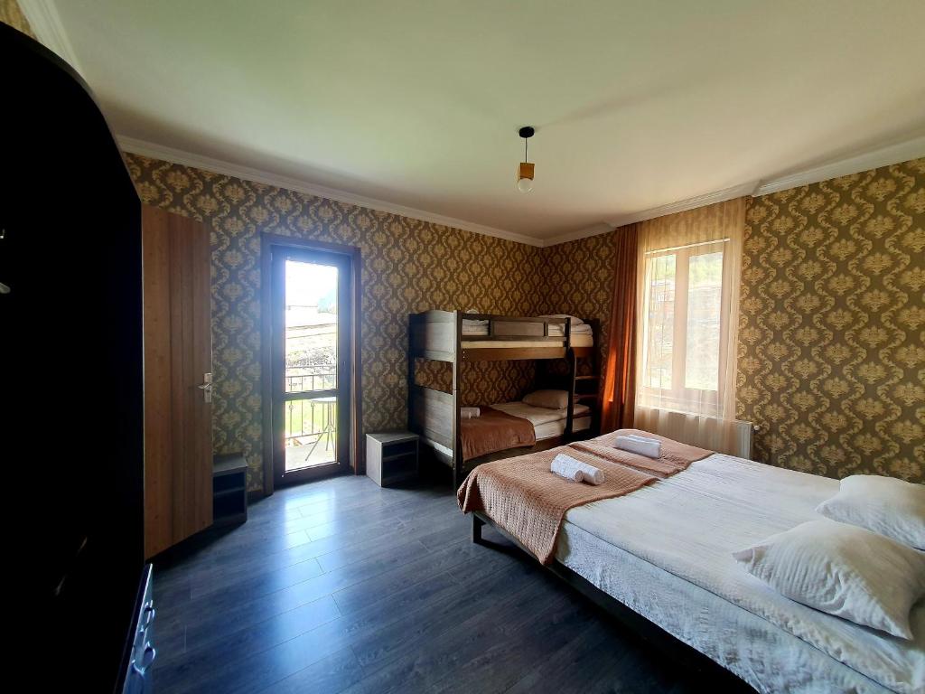 a bedroom with a large bed and a window at Nikolo Inn in Stepantsminda