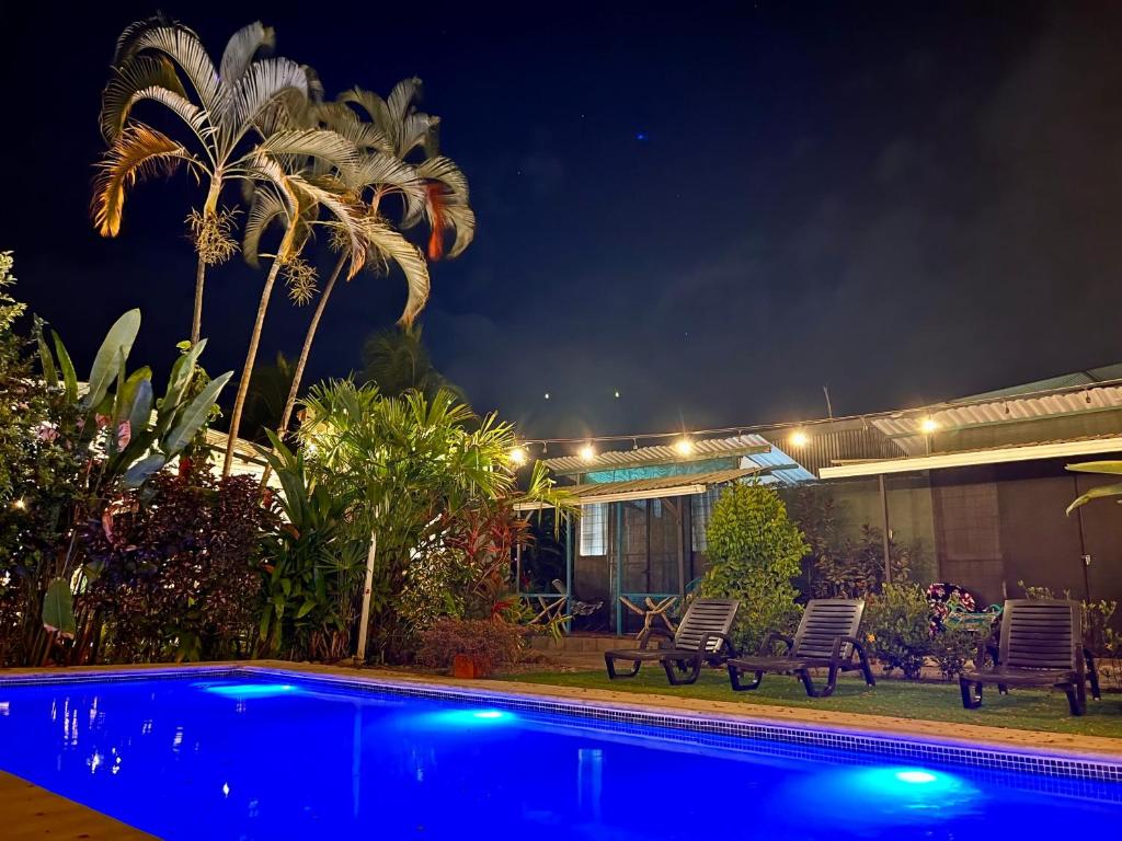 a pool in front of a house at night at Tucan Hotel in Uvita