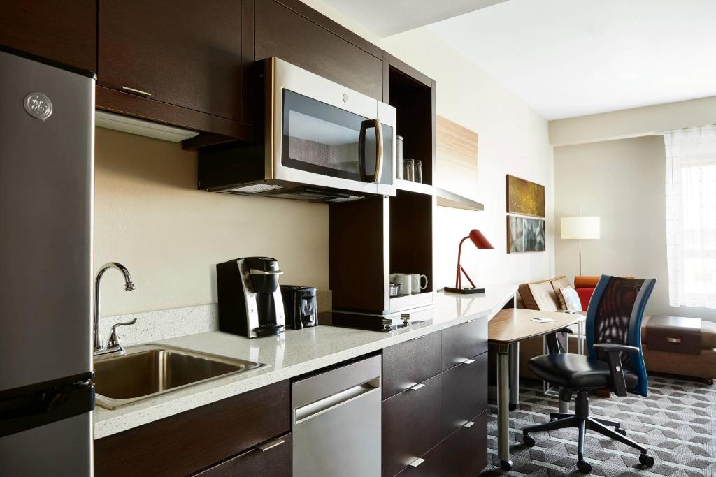 cocina con fregadero y mesa en una habitación en TownePlace Suites by Marriott St. Louis O'Fallon en O'Fallon