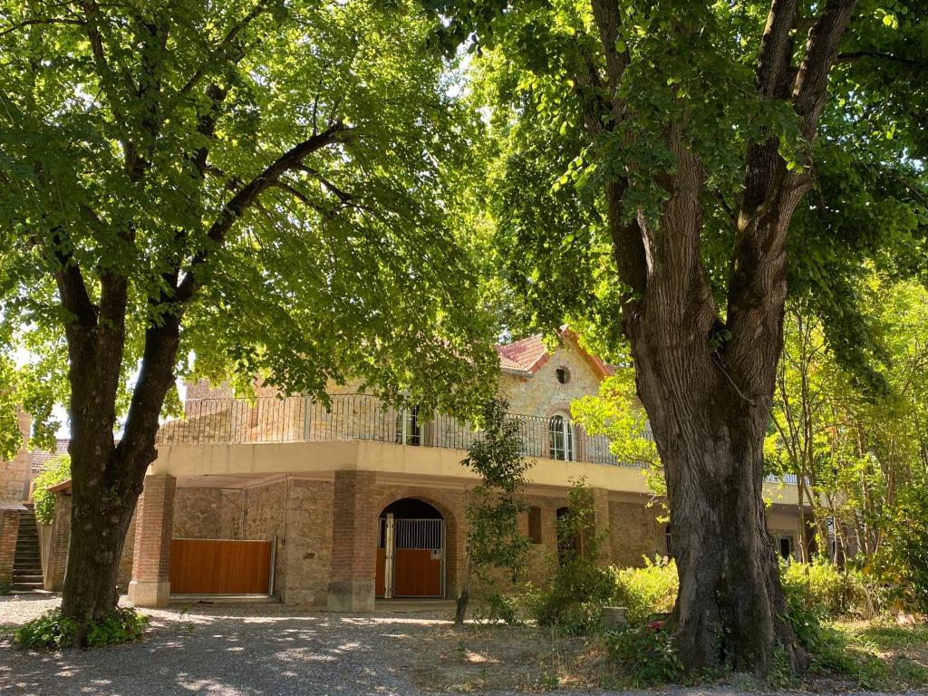 a house with two trees in front of it at Domaine des Églantiers in Cardet