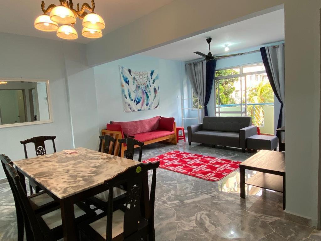 - un salon avec un canapé et une table dans l'établissement Mr Singh Homestay, à Kampong Tanah Merah