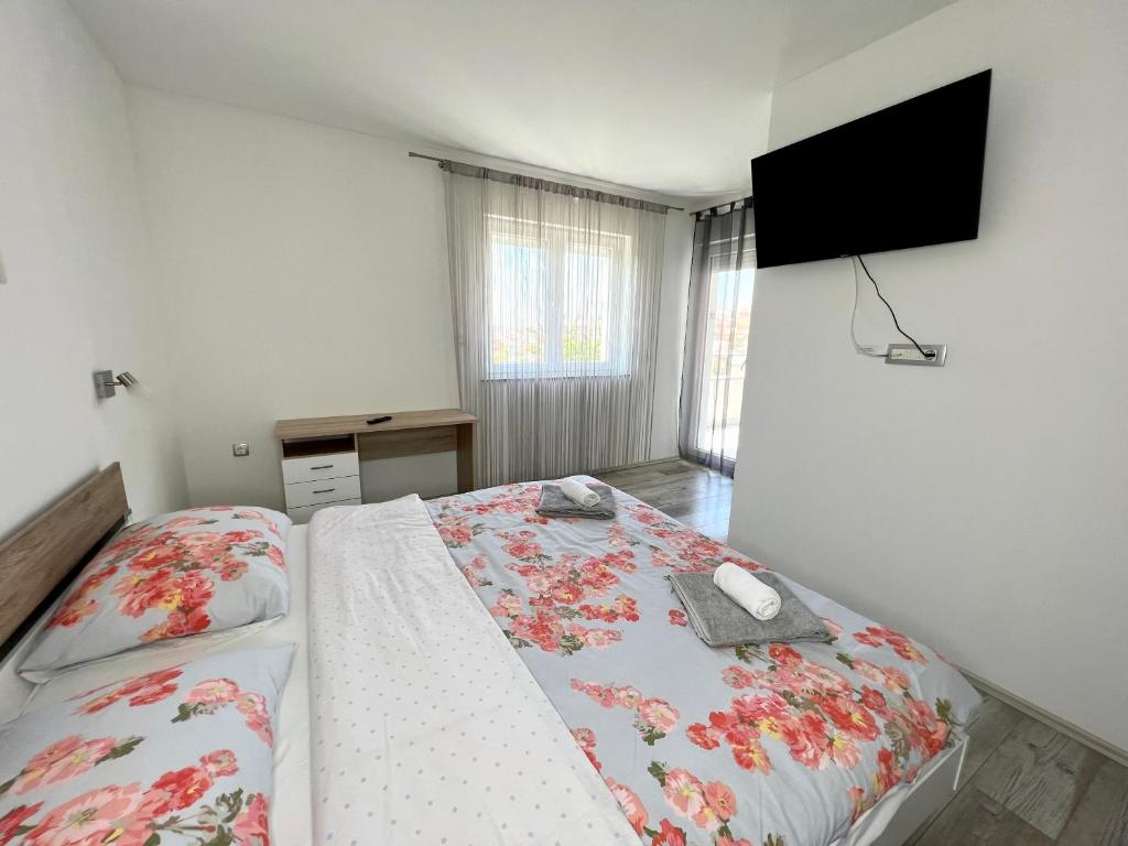 um quarto com uma cama e uma televisão na parede em Apartman Solin 1, parking em Solin