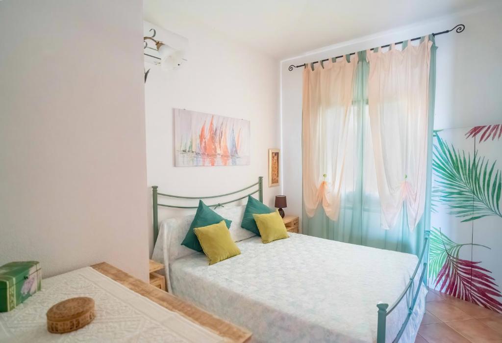1 Schlafzimmer mit 2 Betten und einem Fenster in der Unterkunft Maiorca Sea-view Apartment in Budoni