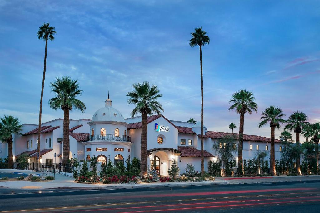 a large building with palm trees in front of it at Triada Palm Springs, Autograph Collection in Palm Springs