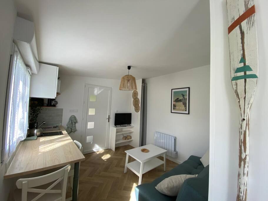 eine Küche und ein Wohnzimmer mit einem Sofa und einem Tisch in der Unterkunft Studio au calme St Marc sur Mer in Saint-Nazaire