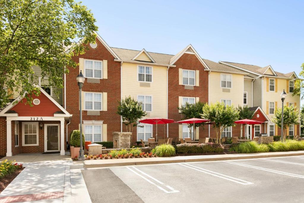 un edificio con sombrillas rojas frente a una calle en TownePlace Suites Gaithersburg, en Gaithersburg