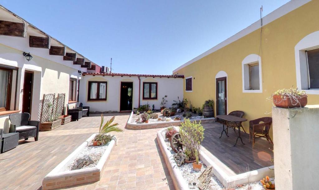 a patio with potted plants and a building at La Tankitta Turismo Rurale in Stintino