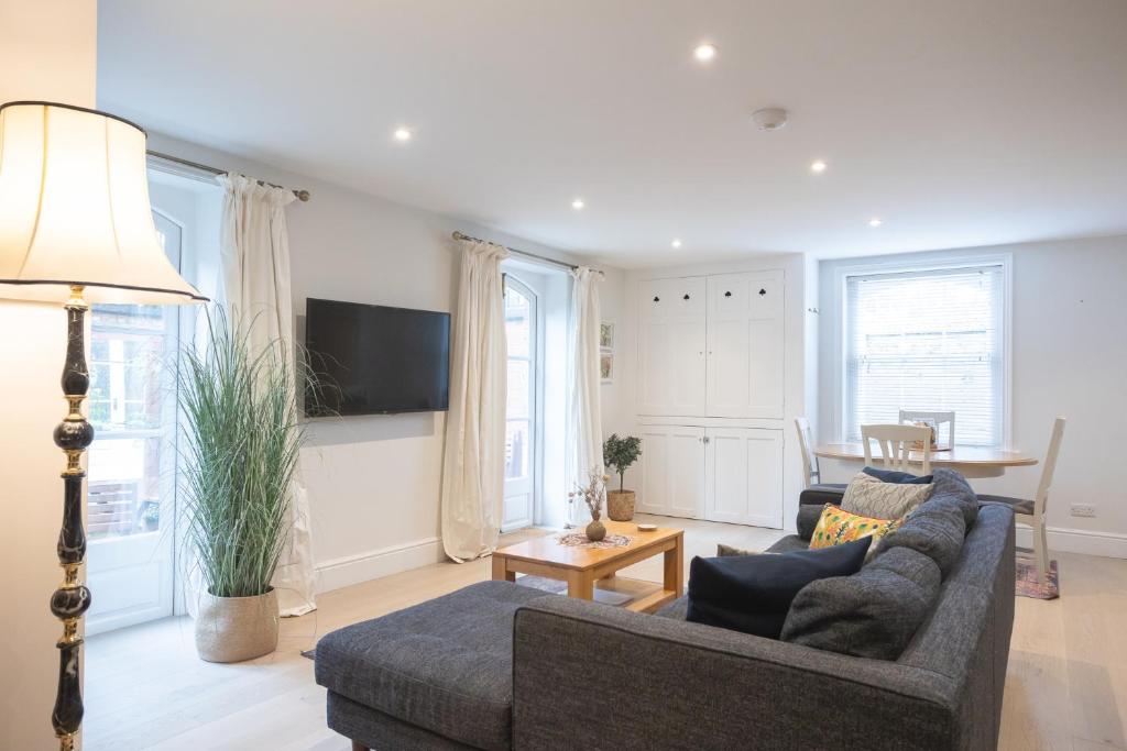 a living room with a couch and a table at Spacious 2BR Victorian Cheltenham flat in Cotswolds Sleeps 6 - FREE Parking in Cheltenham