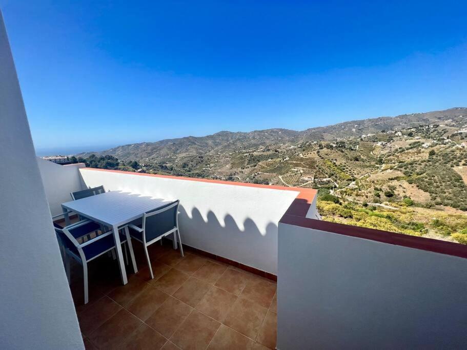 d'une table et de chaises sur un balcon avec vue. dans l'établissement Ático con increíbles vistas a las montañas y mar, à Frigiliana