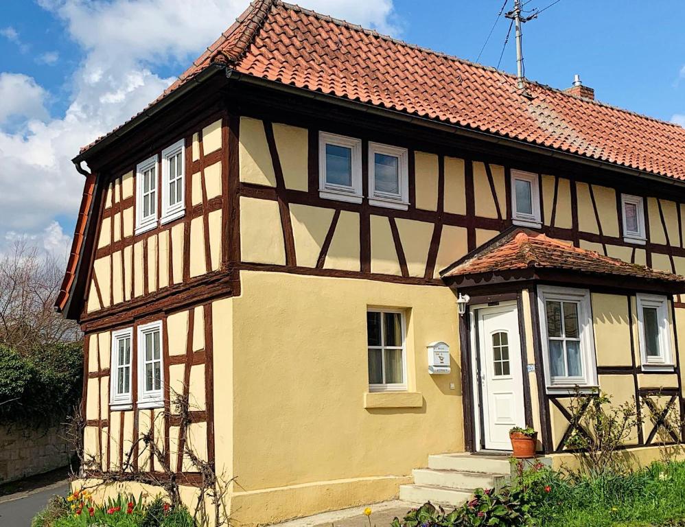 a yellow house with a red roof at Historisches Fachwerkhaus in Königsberg in Bayern