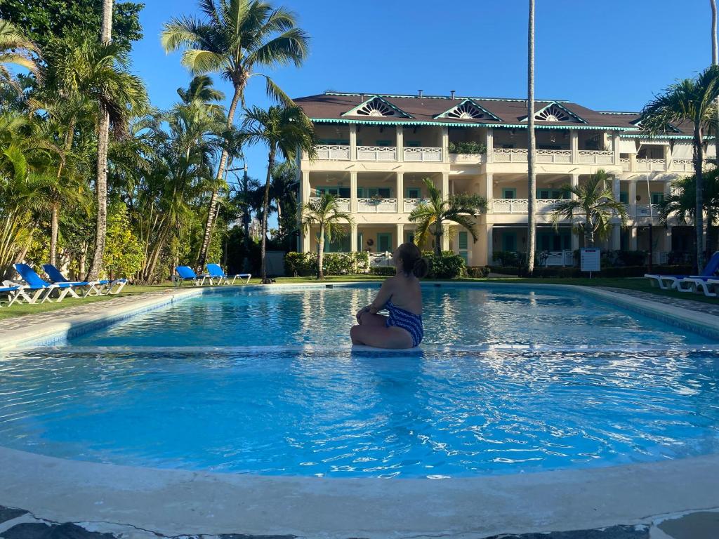 una mujer sentada en la piscina en un resort en La Dolce Vita Rental, Las Terrenas, Samana, en Santa Bárbara de Samaná