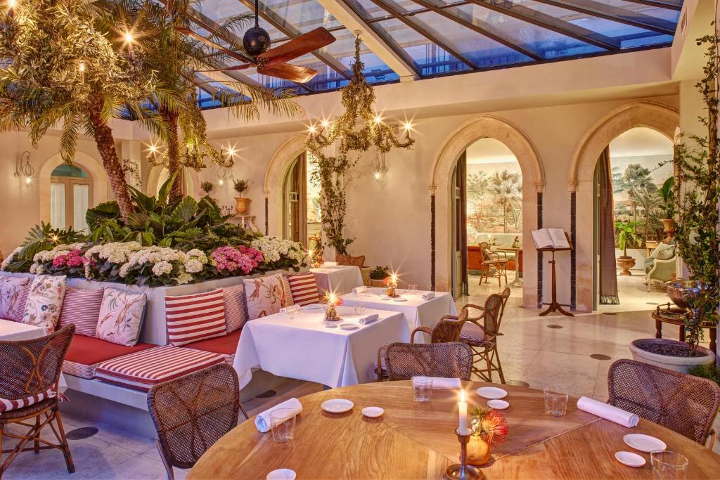 un restaurant avec des tables et des chaises et une grande salle dans l'établissement Palazzo Vecchio Taormina, à Taormine