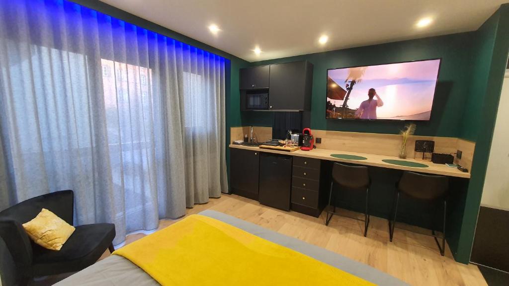 um quarto com uma secretária e uma televisão na parede em Studio L'élégance Place de Jaude et garage em Clermont-Ferrand