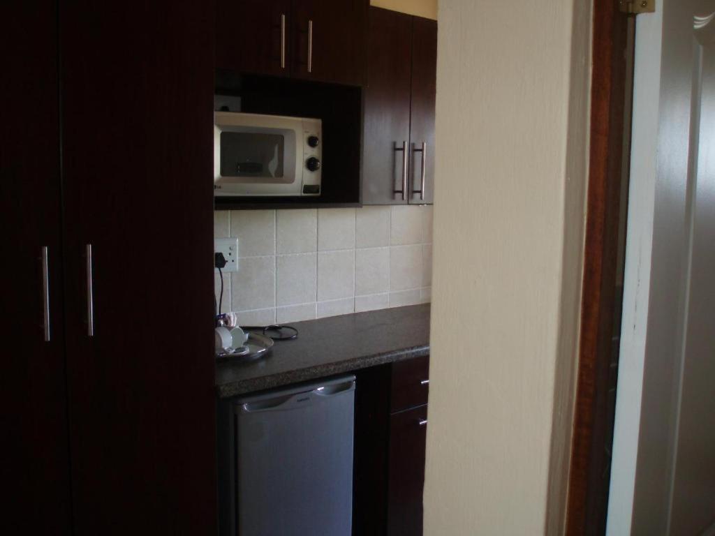 een keuken met een wastafel en een magnetron bij F19 Ocean View Villas in Port Edward