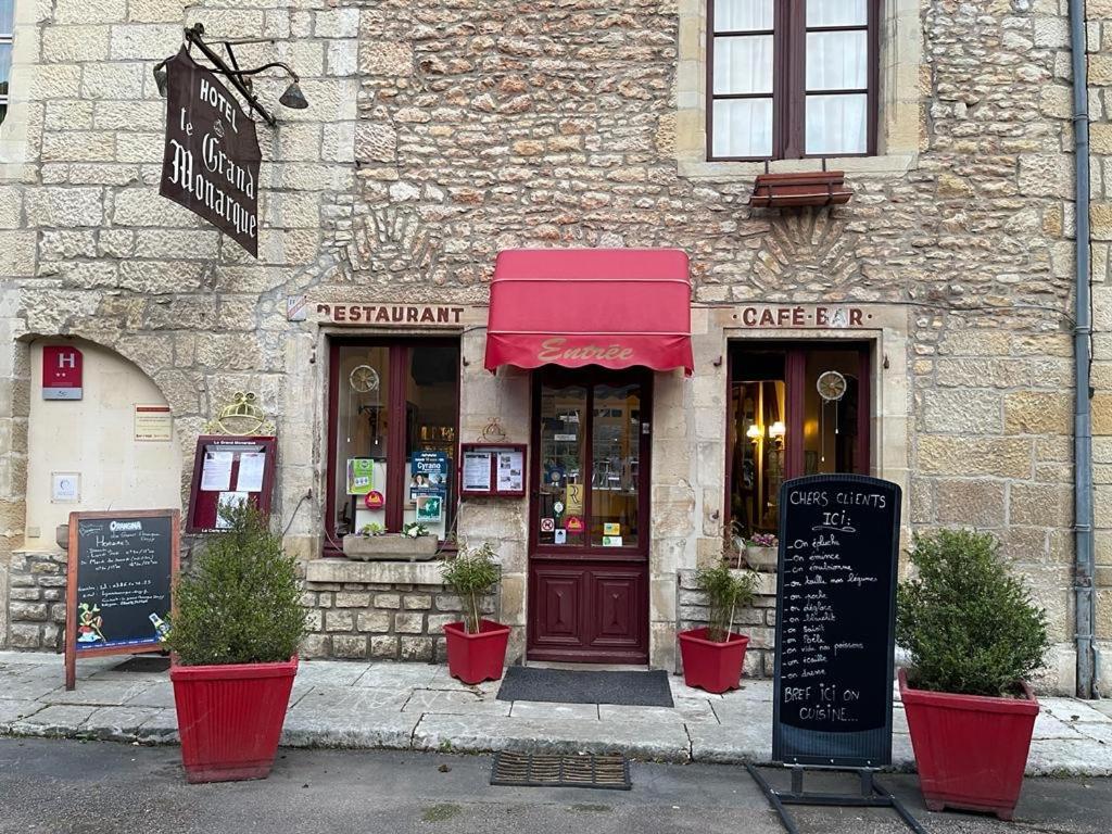 a building with a sign in front of a store at Le Grand Monarque Donzy in Donzy