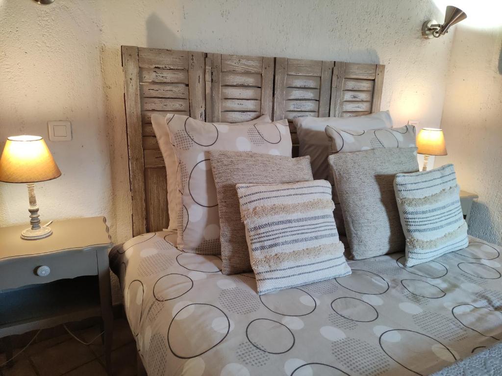 Un dormitorio con una cama con almohadas. en La Maison des Hautures, en Arles
