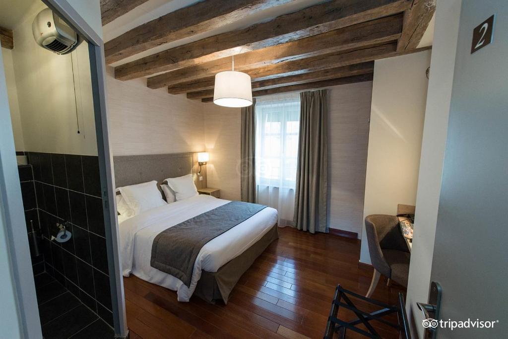 a hotel room with a bed and a window at Relais de la Loire in Montlivault