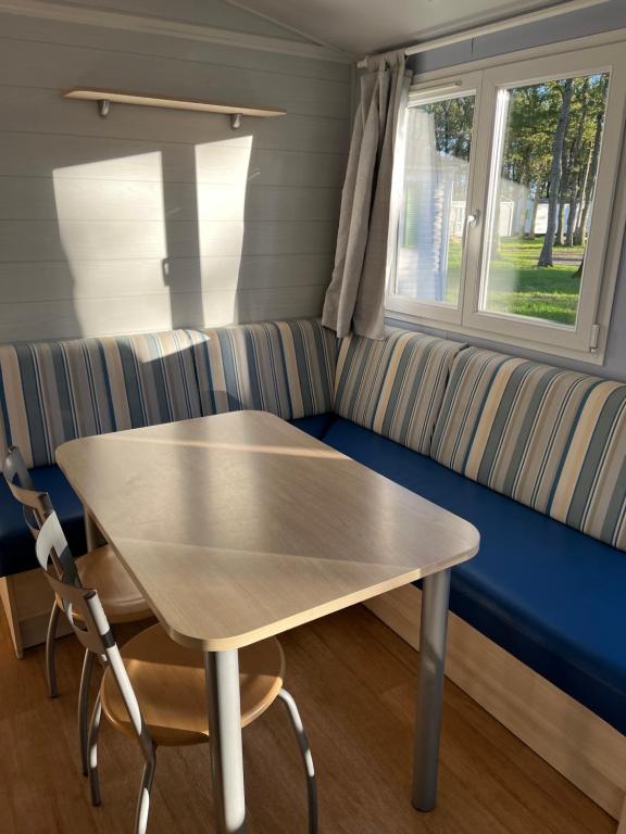 - une table et des chaises dans une chambre avec un canapé dans l'établissement Coeur de Vendee, à La Boissière-de-Montaigu