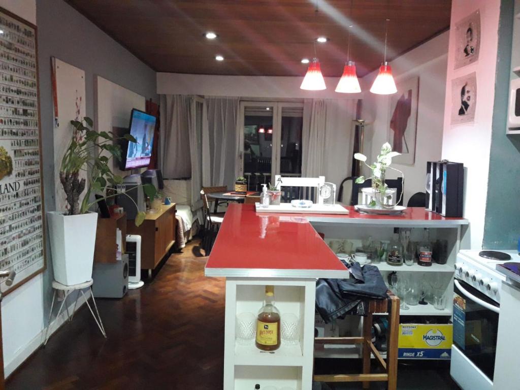 a kitchen with a table with a red counter top at Tu lugar Departamento 2 ambientes Hindu Club Don Torcuato in Don Torcuato