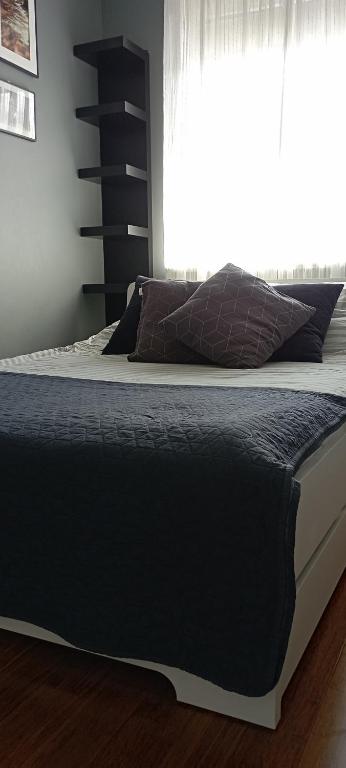 Una cama en un dormitorio con ventana. en Apartament Komfort, en Zamość