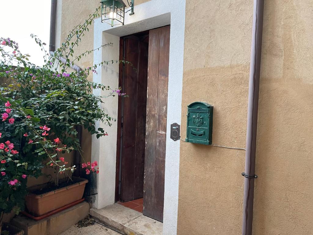 a green mailbox next to a door with flowers at La Finestra Sul Porto in Termoli