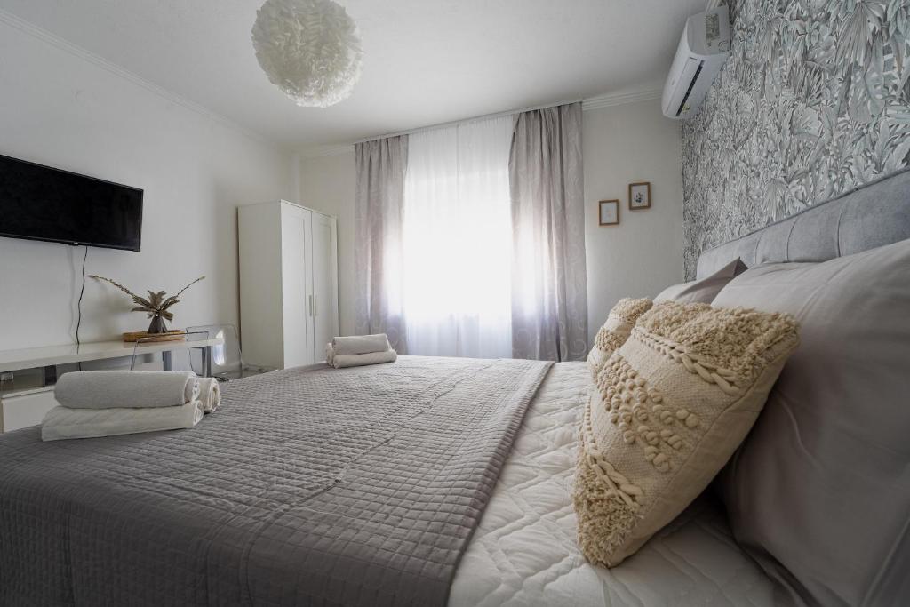 una camera bianca con un grande letto e una finestra di Silver Room a Zara (Zadar)