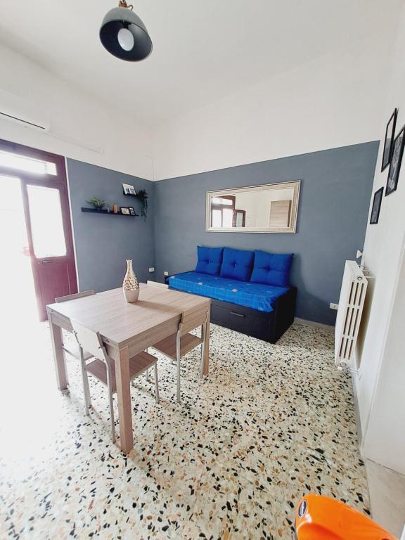 uma sala de estar com um sofá azul e uma mesa em La Casa del Borgo em Lecce