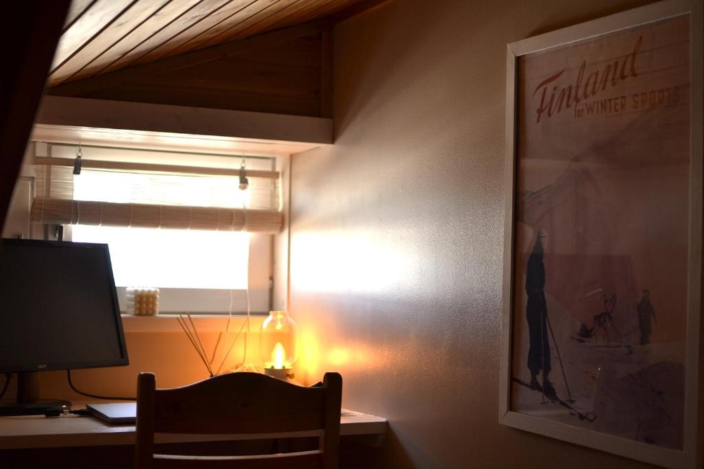 Cette chambre comprend un bureau avec un moniteur et une fenêtre. dans l'établissement One-bedroom apartment in the center of Saariselkä, à Saariselka