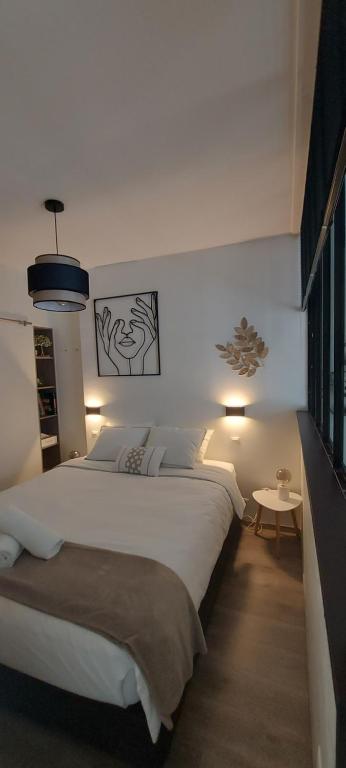 Un dormitorio con una gran cama blanca y una mesa en Studio Belle-Vue, en Spa