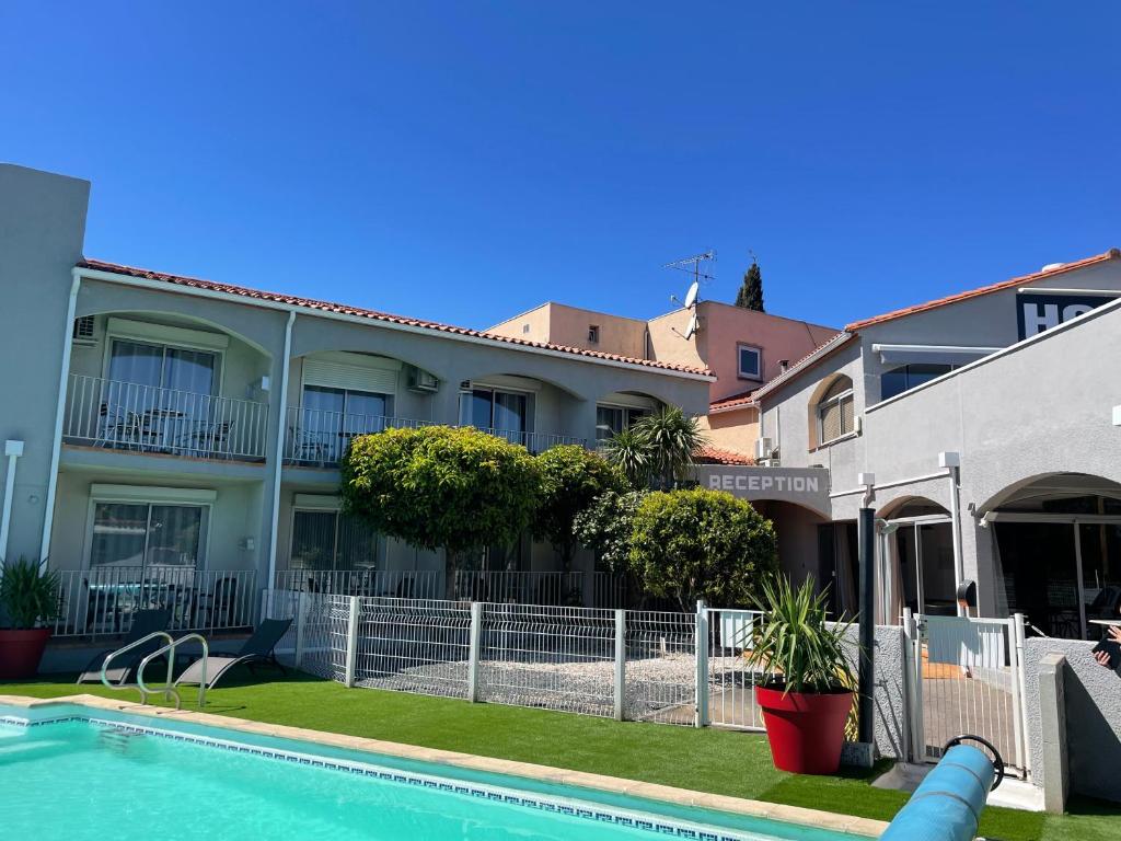 a house with a swimming pool in front of a building at Acapella Hotel in Argelès-sur-Mer