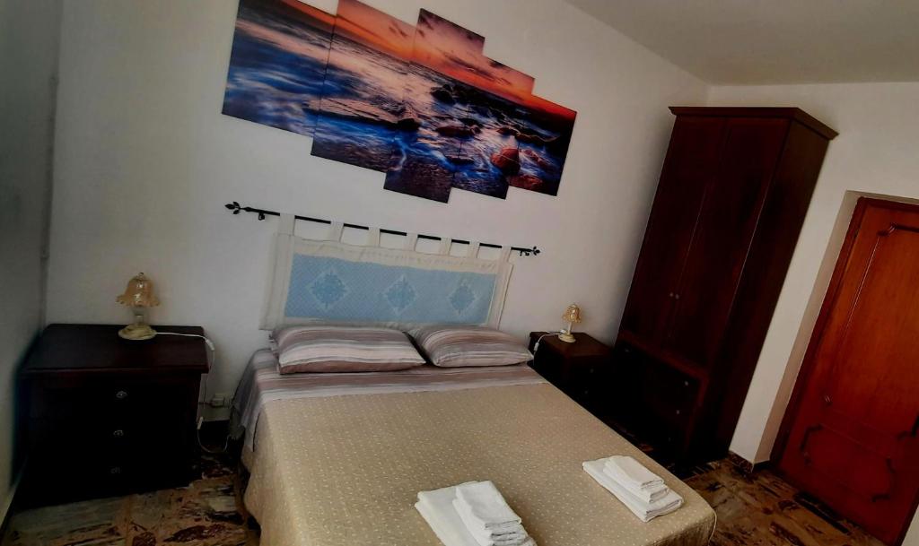 una camera da letto con un letto e un dipinto sul muro di janas a Tortolì