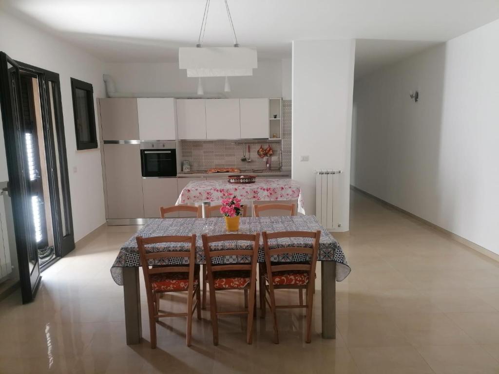 cocina y comedor con mesa y sillas en Albachiara, en Galatina