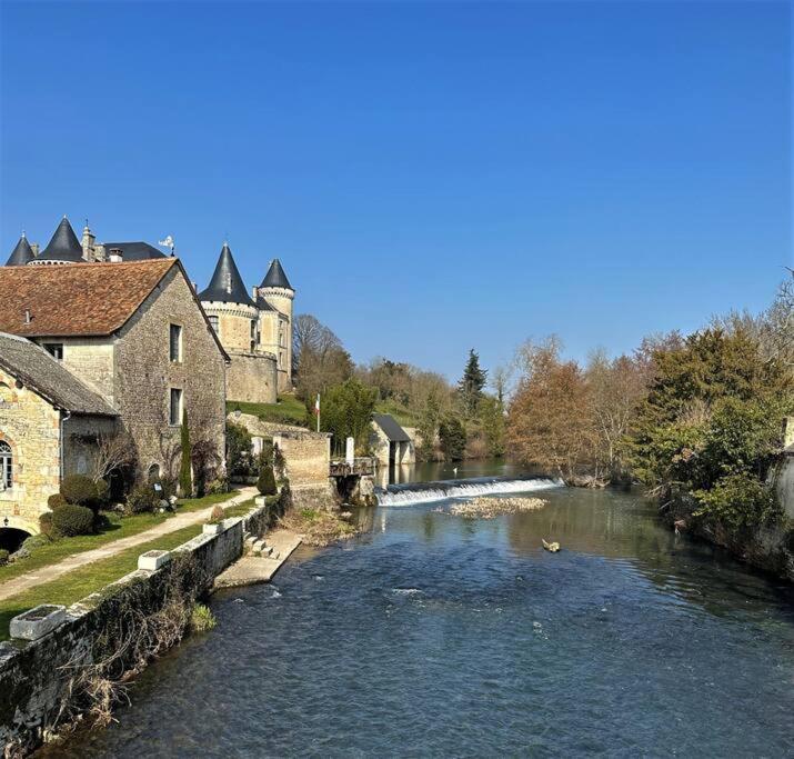 a river in front of a building and a house at Happiness Verteuil sur Charente in Verteuil-sur-Charente