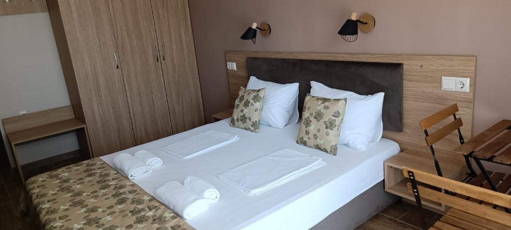 a bedroom with a bed with white sheets and pillows at Апартаменти Детелини in Primorsko