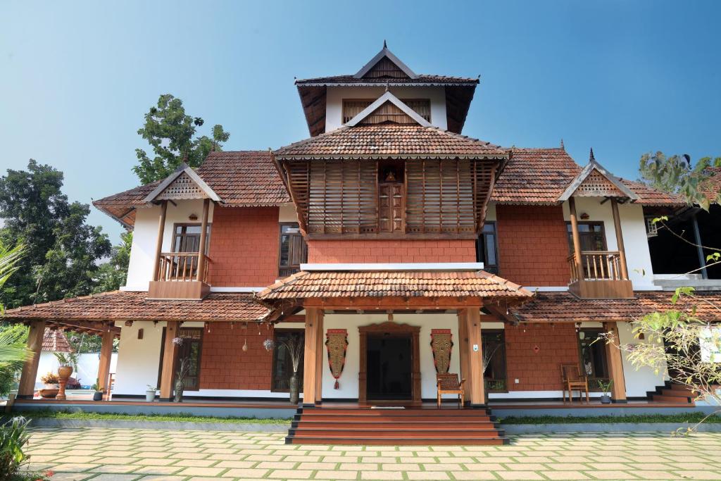 a large red brick building with a roof at Vajra Ayurveda and Yoga Retreat in Cochin