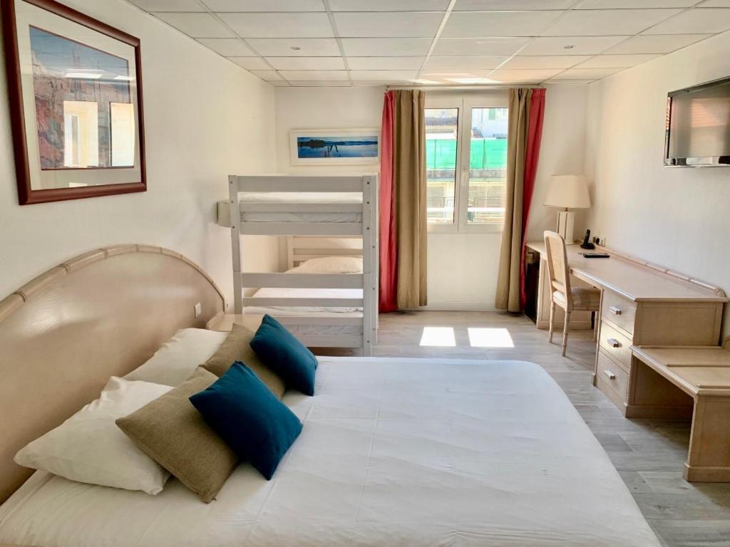 サン・ラファエルにあるオテル ド フロールのベッドルーム1室(ベッド1台、デスク、二段ベッド1組付)
