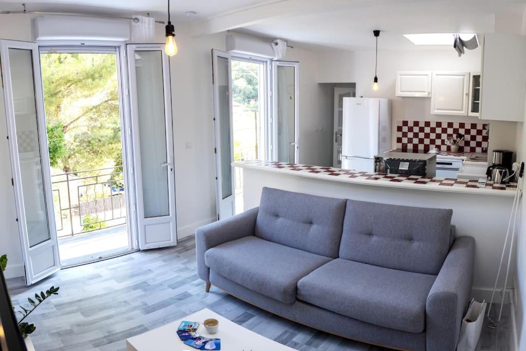 a living room with a couch and a kitchen at Logement Le Serein in Toulon