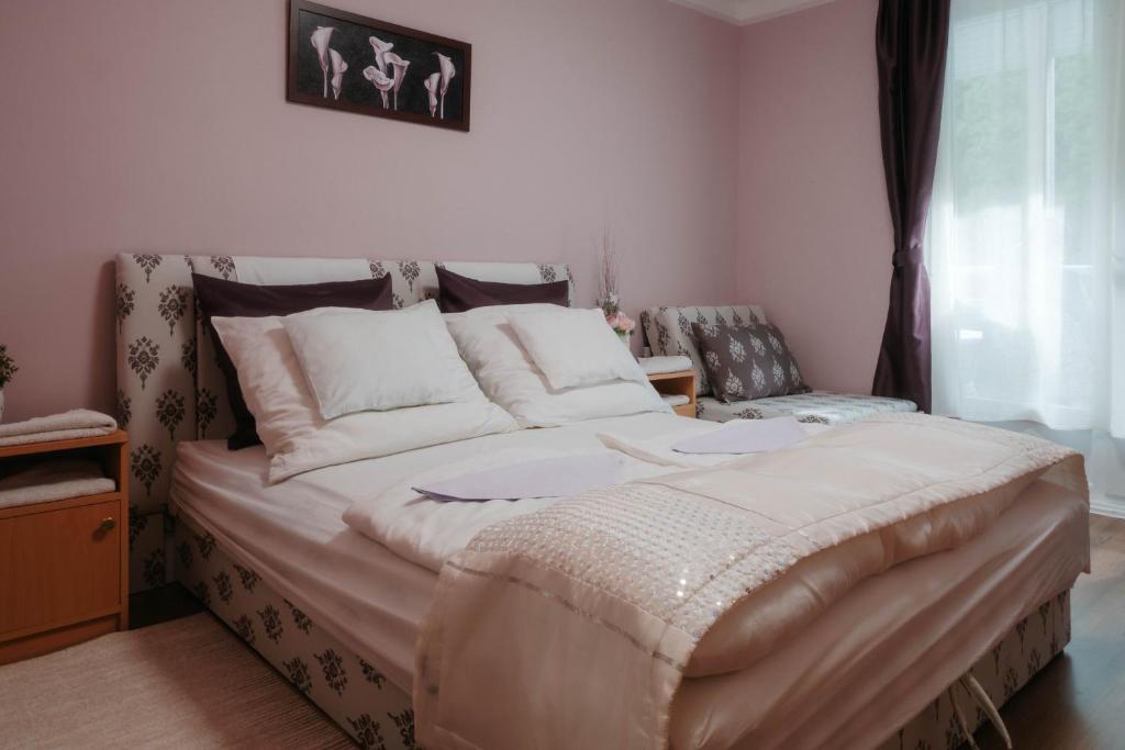 1 dormitorio con 1 cama grande y 1 silla en Relax Home, en Harkány