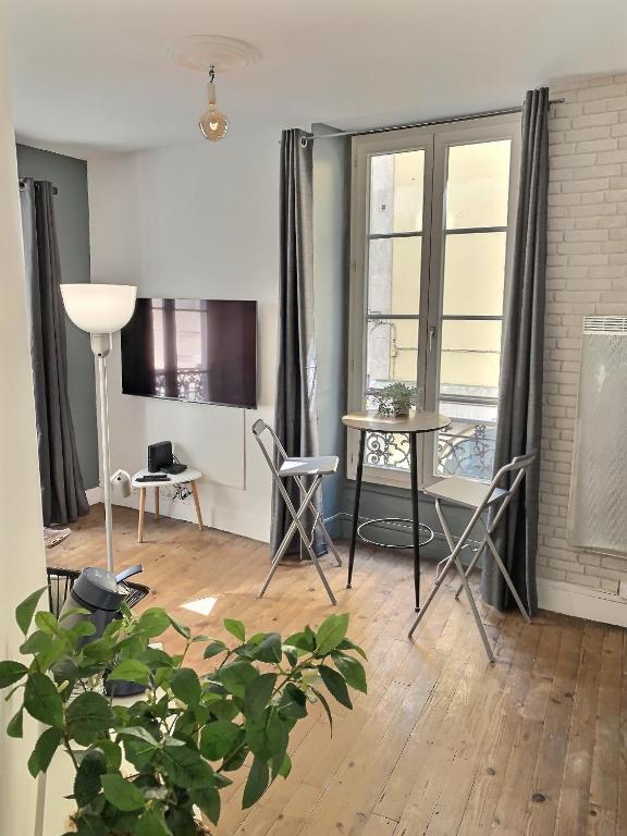 un salon avec une table et des chaises dans l'établissement Quartier historique et populaire du château de Pau, à Pau