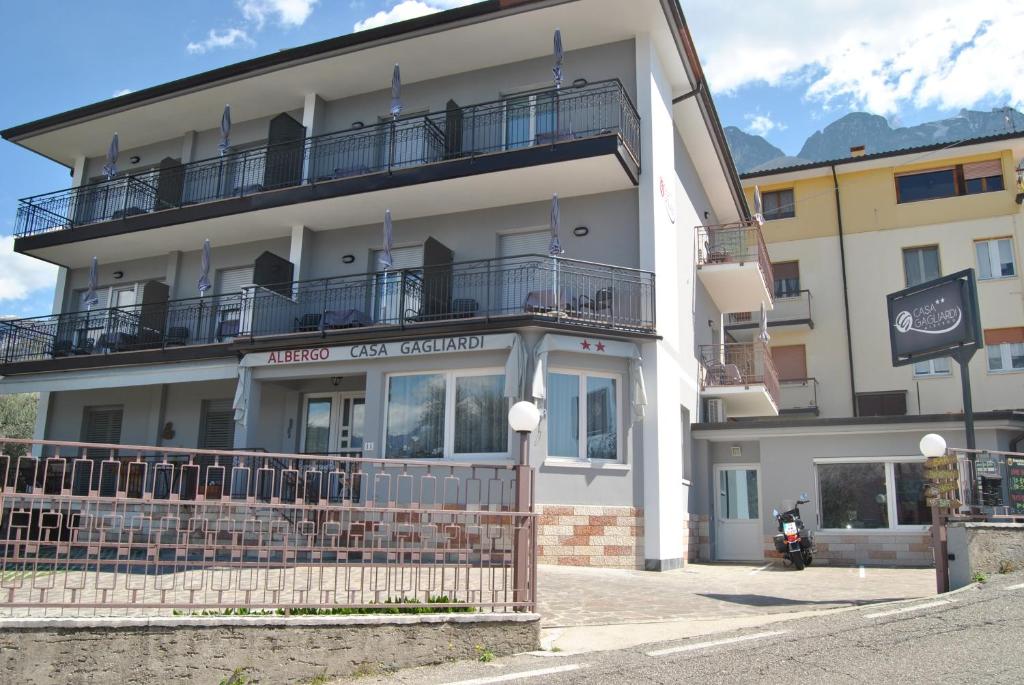 a white building with a balcony on top of it at Hotel Casa Gagliardi in Brenzone sul Garda