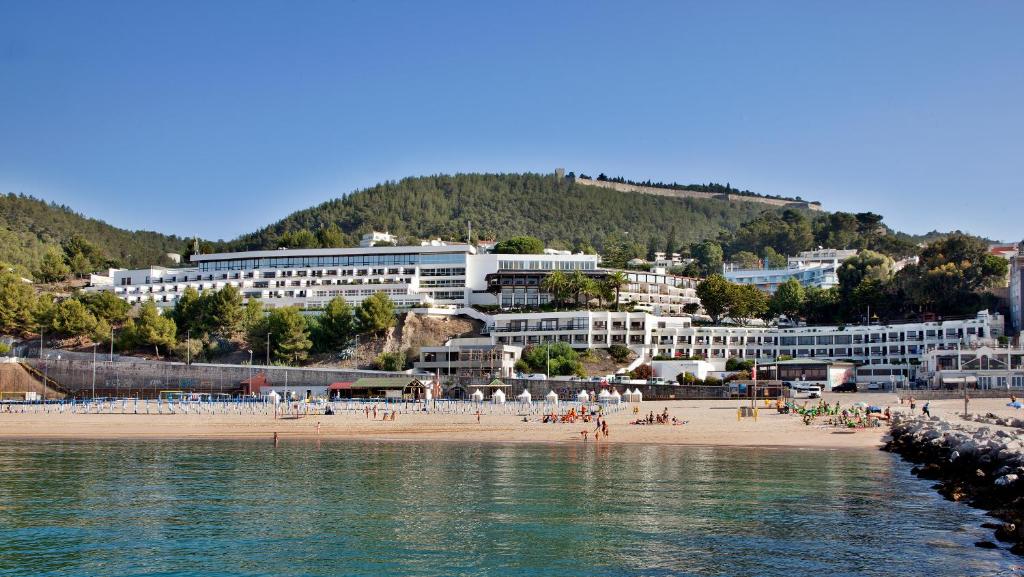 a group of people on a beach near the water at Hotel do Mar in Sesimbra